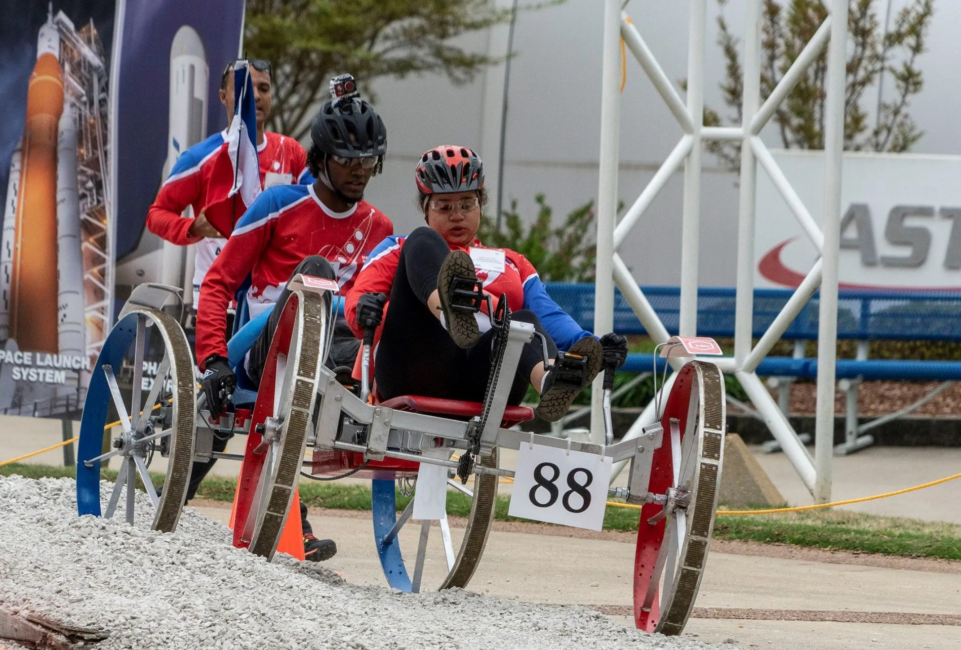 Teams operate their rover on a gravel track while participating in the Human Exploration Rover Challenge (HERC).