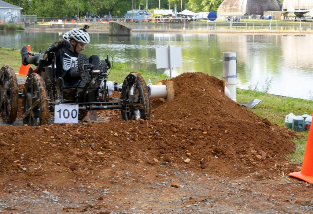 Students operating a rover on a dirt track while they participate in the Human Exploration Rover Challenge (HERC).