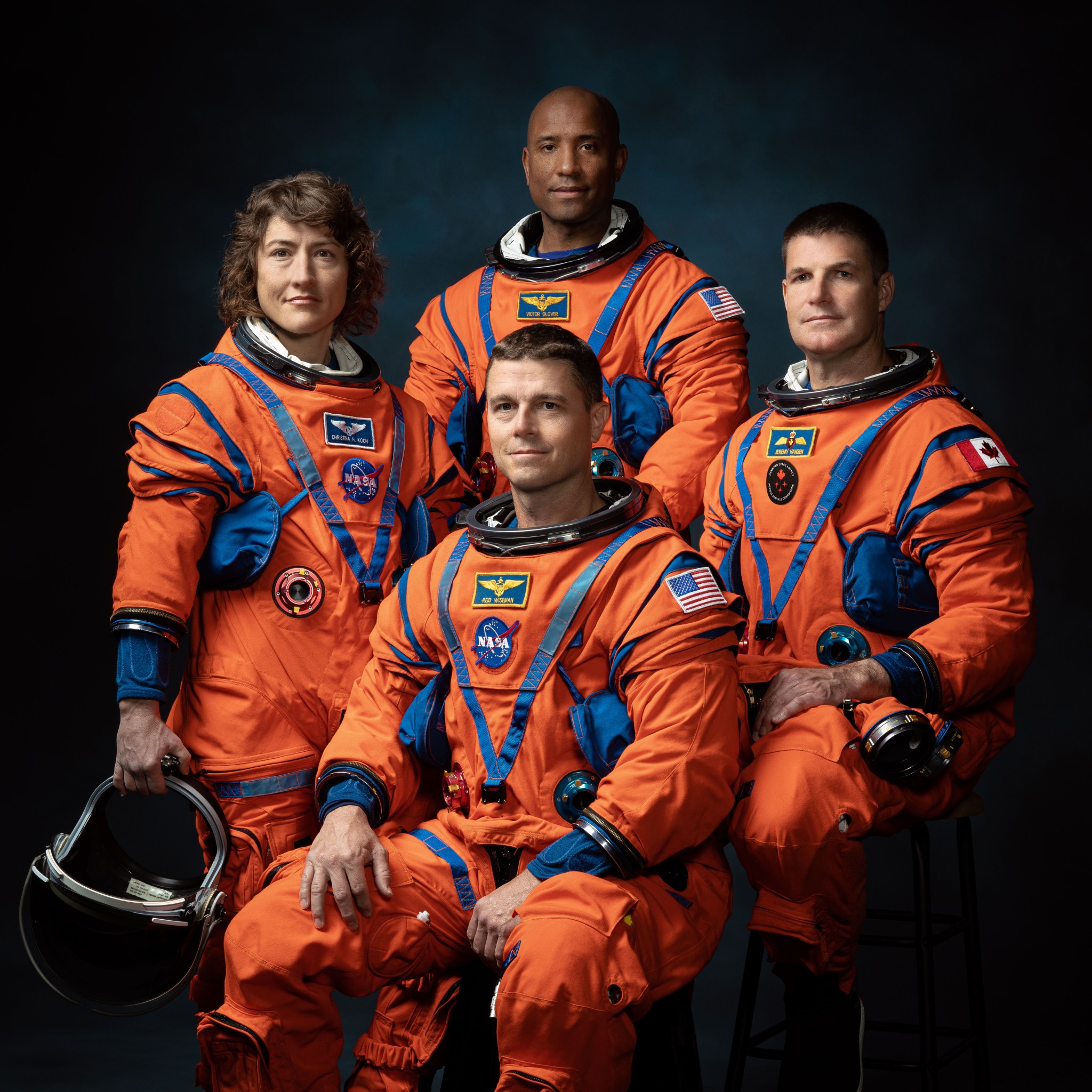 The crew of NASA’s Artemis II mission in orange flight suits (left to right): NASA astronauts Christina Hammock Koch, Reid Wiseman (seated), Victor Glover, and Canadian Space Agency astronaut Jeremy Hansen.