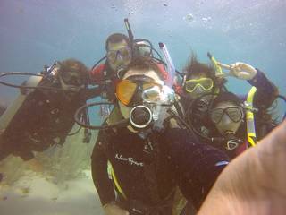 Juan Torres-Pérez poses with colleagues shown underwater wearing diving gear.