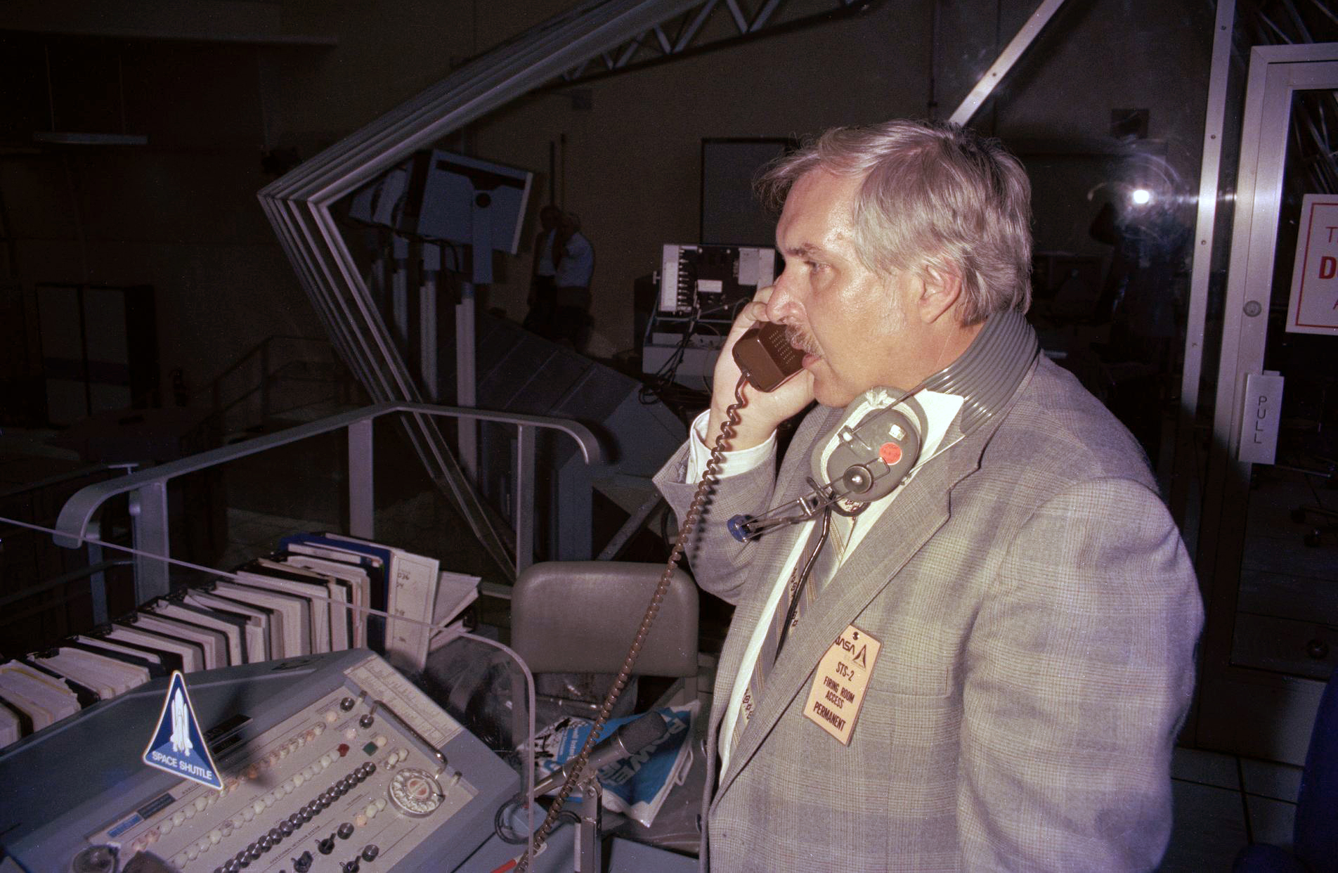 Man talking on telephone and looking out window.