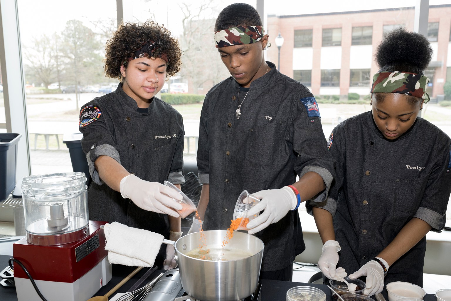 The Phoebus High School culinary team working together to prepare their dish for the judges at the HUNCH Culinary Challenge at NASA's Langley Research Center.