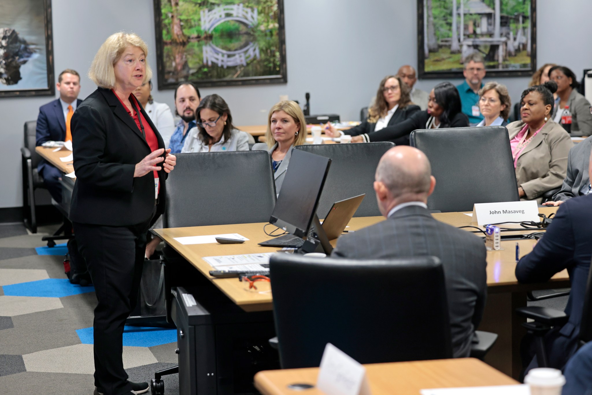 NASA Deputy Administrator Pam Melroy speaks to a group in a conference room as they sit at multiple tables.