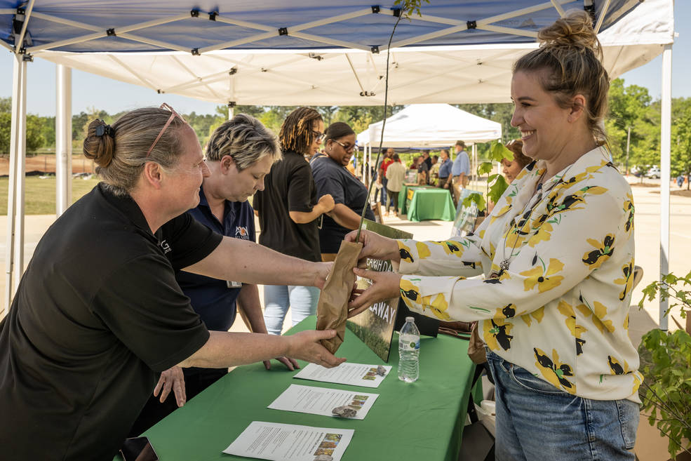 A Marshall team member is handed one of the more than 600 free tree saplings that were given away during the center’s Earth Day event on April 19. 