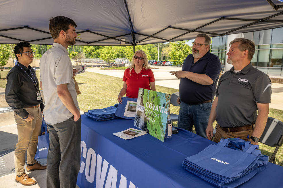 Marshall team members speak with representatives from Covanta, one of the vendors during Marshall’s Earth Day event. 