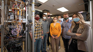 Members of the PEACOQ team stand next to a JPL cryostat that was used to test the detector. From left, Alex Walter, Sahil Patel, Andrew Mueller, Ioana Craiciu, Boris Korzh, Matt Shaw, and Jamie Luskin.
