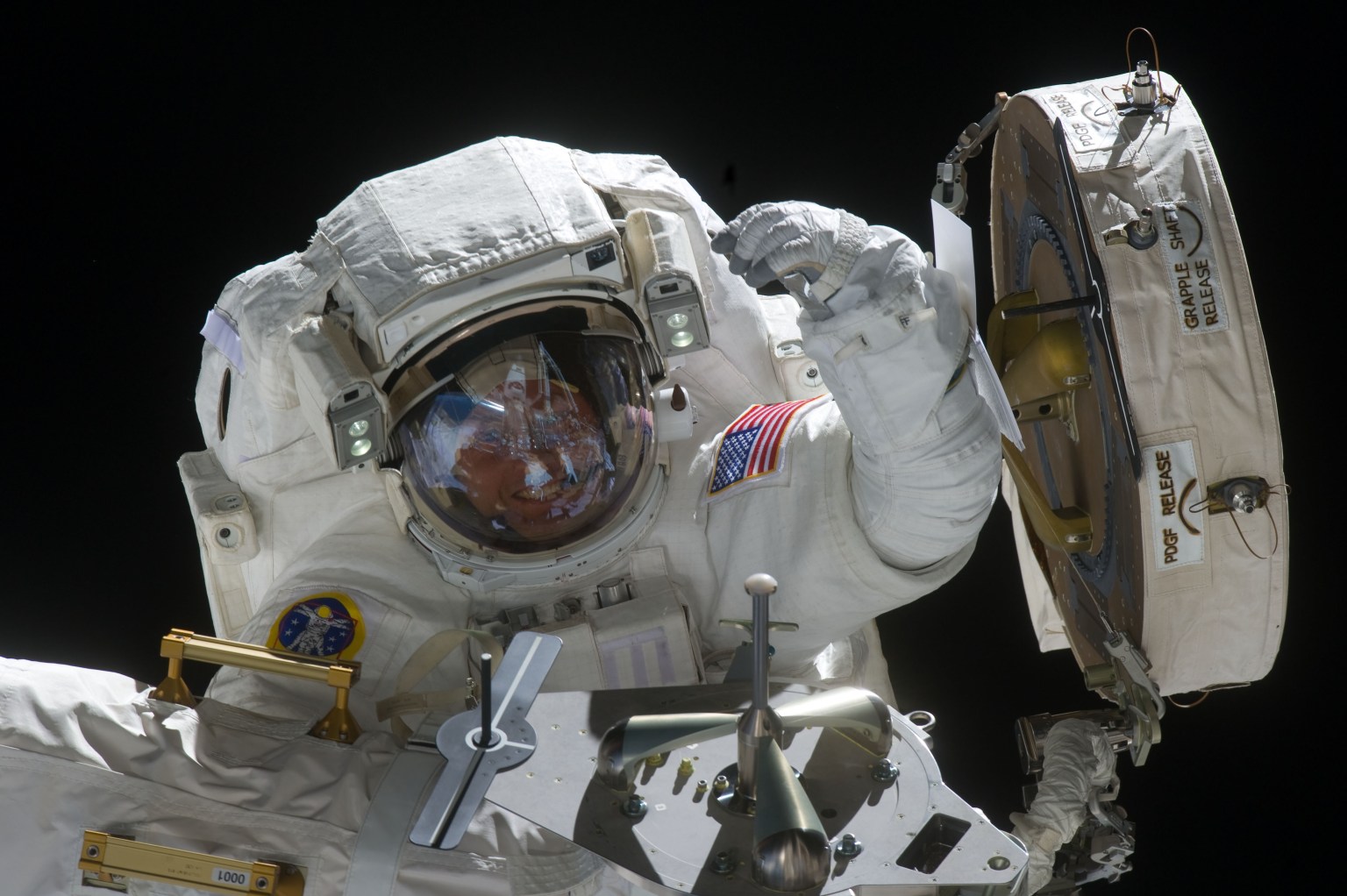 View of STS-134 Mission Specialist (MS-1) Michael Fincke waving while working to install the OBSS (Orbiter Boom Sensor System)