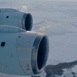 Image of the two engines under the wing of the aircraft flying over the Antarctic.