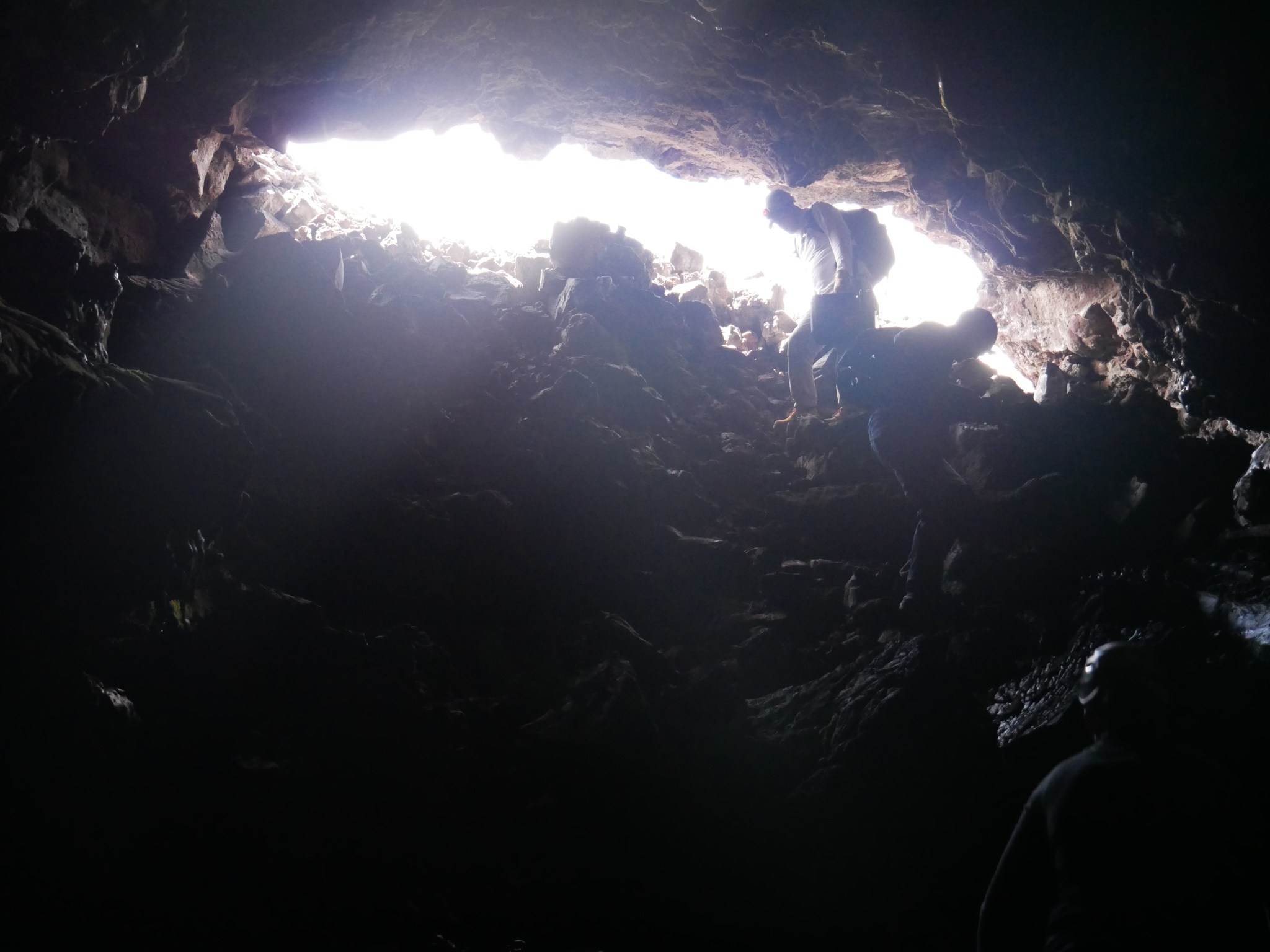 Image of scientists entering a lava tube cave.