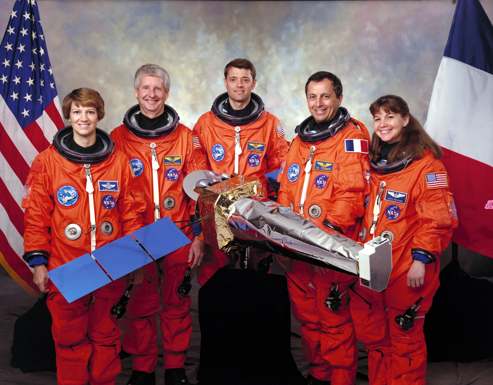 The crew of five astronauts for STS-93 in orange spacesuits pose for portrait