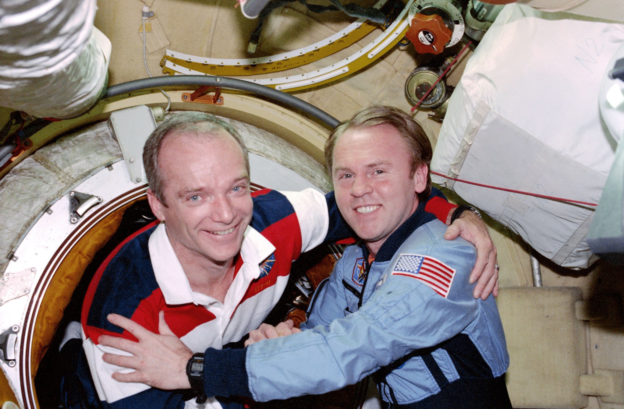 Astronauts Charles J. Precourt and Andrew S.W. Thomas are pictured together embracing after the hatch opening between the Space Shuttle Discovery and the Mir space station.