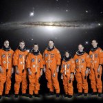 Six men and one woman in flight suits, no helmets, standing in front of a backdrop of a galaxy image.
