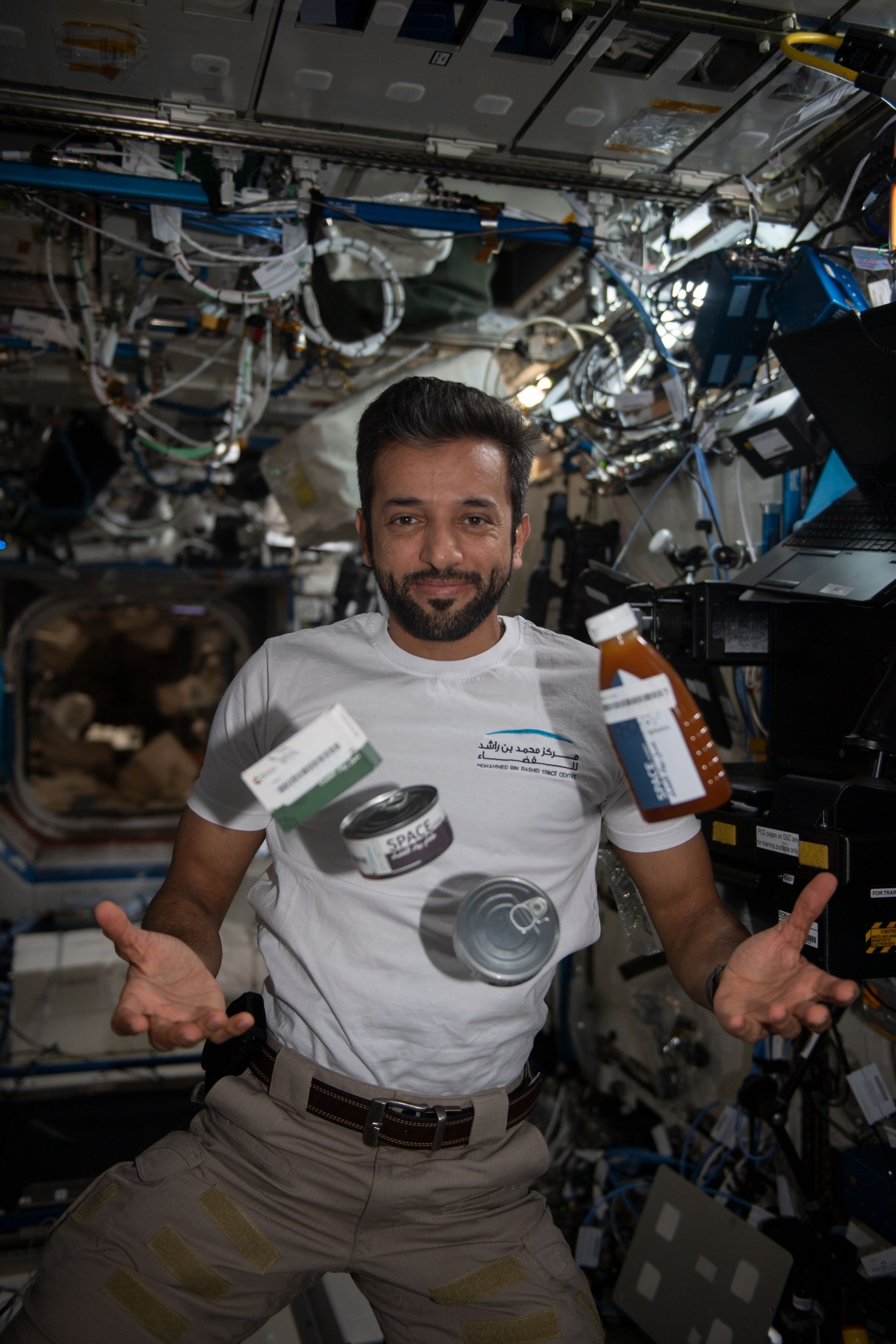 UAE (United Arab Emirates) astronaut Sultan Alneyadi with food canisters and packages in the International Space Station. Food Physiology examines how an enhanced spaceflight diet affects various aspects of crew health and performance.