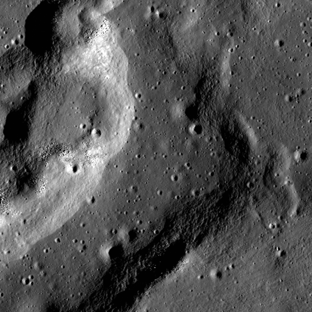 A complex wrinkle ridge in Mare Crisium at low Sun, seen in an image captured by the Lunar Reconaissance Orbiter Camera (illumination is from the right). Image width is 700 m, north is up. Boulders occupy the tops of mounds on the west ridge, and the central depression is more heavily cratered than the ridge.