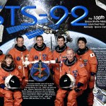 STS-92 crew poster with the crew in orange flight suits and the ISS in the background