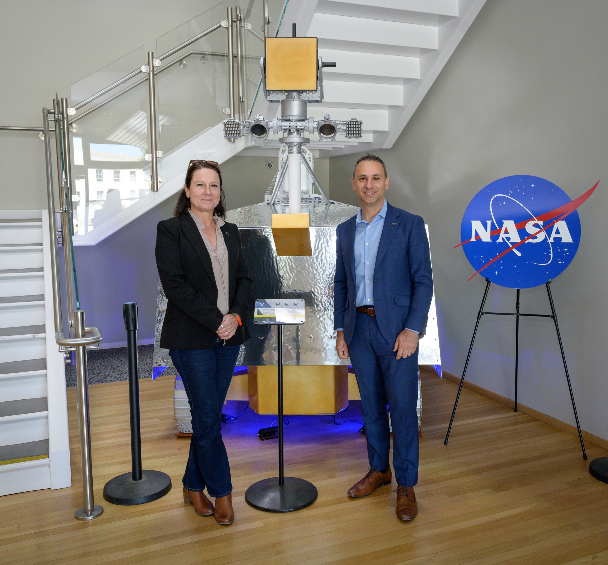 Aude Vignelles, chief technology officer for the Australian Space Agency (ASA), and Enrico Palermo, head of the ASA, stand next to a full-scale model of NASAs Volatiles Investigating Polar Exploration Rover (VIPER) at NASA Ames.