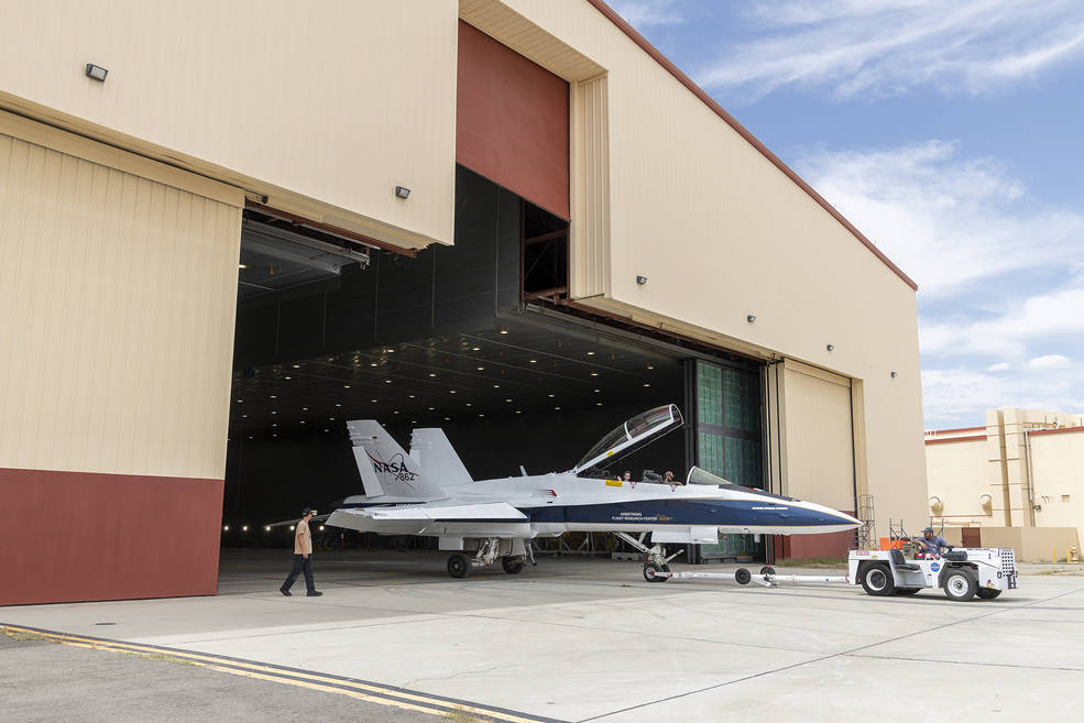 A NASA chase aircraft is towed from the hangar where it was painted.