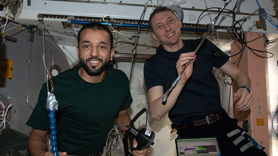 Astronauts (from left) Sultan Alneyadi and Woody Hoburg show off the tools they used to successfully open a hatch on the Unity module.