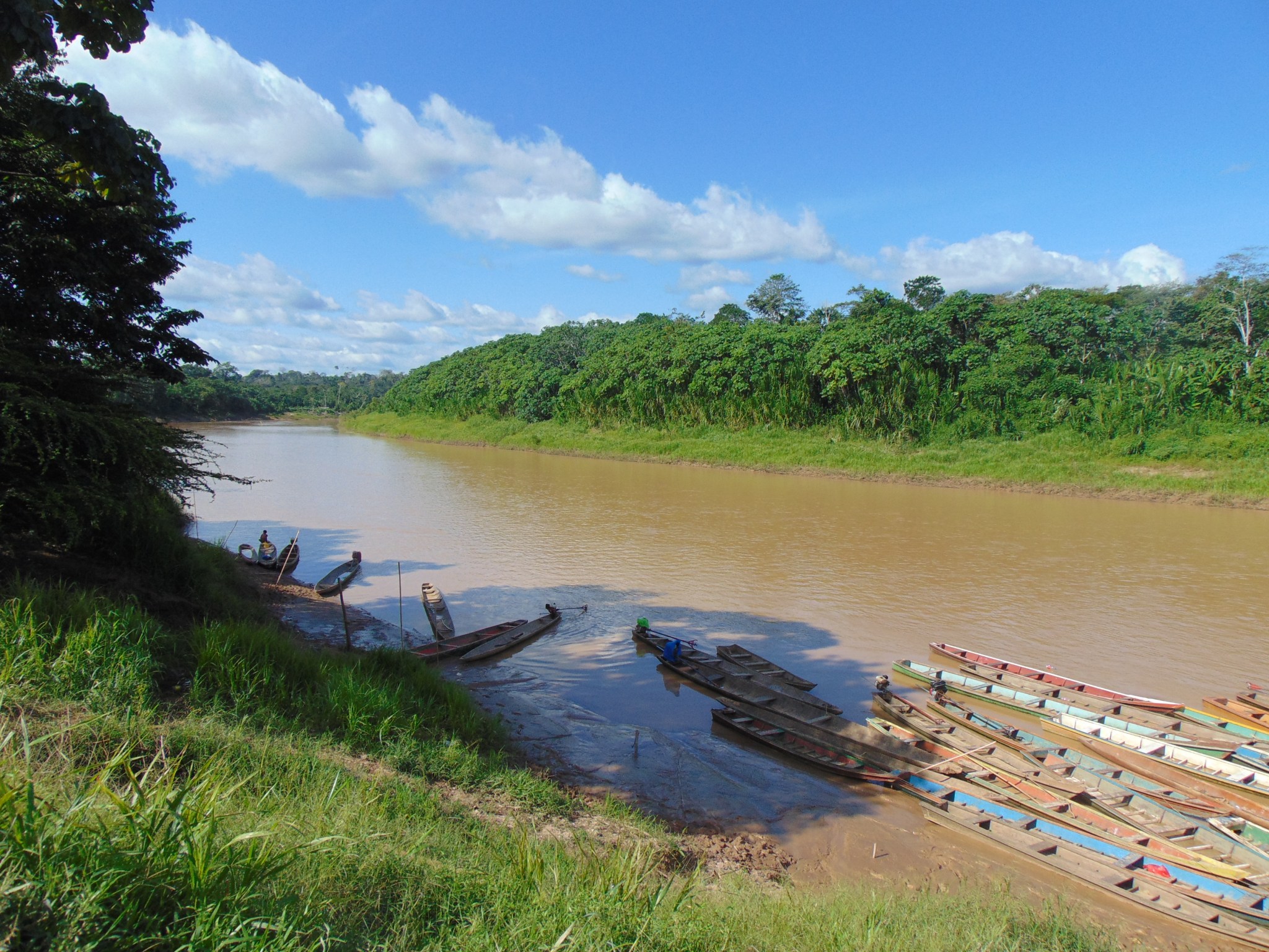 The view of a river that looks brown with boats along the bank.