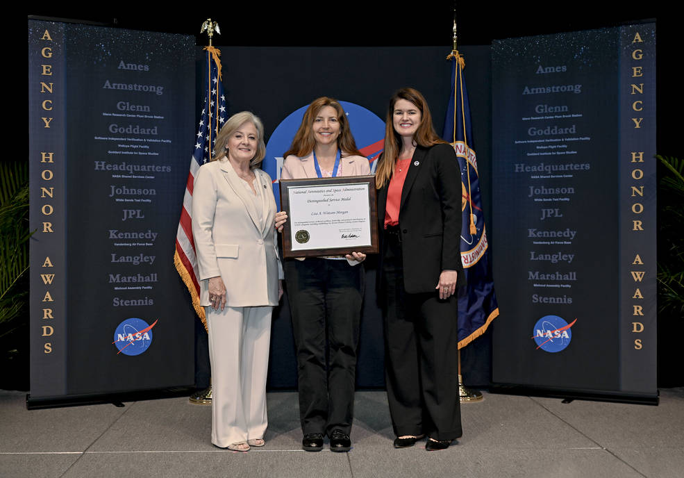 Dr. Lisa Watson-Morgan, center, displays her Distinguished Service Medal and award certificate while standing between Singer, left, and Swails. 