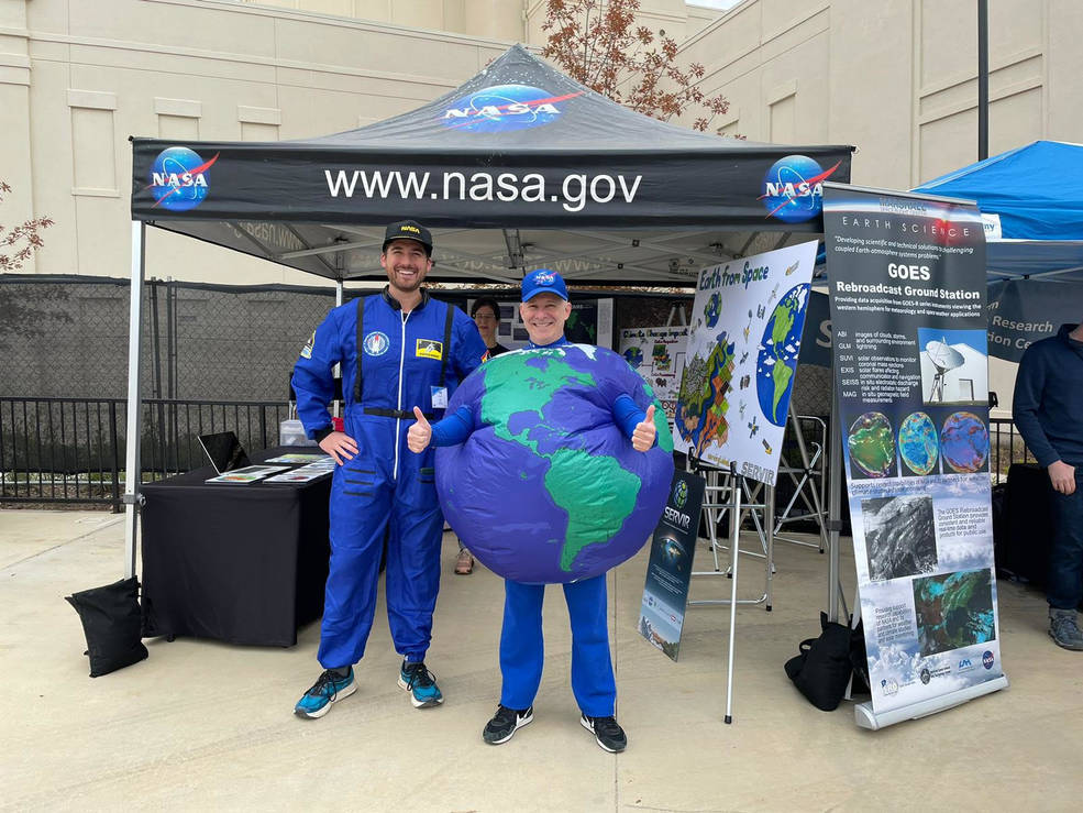 NASA SERVIR’s Regional Science Lead Tim Mayer, left, dressed as a NASA astronaut, and SERVIR’s Program Manager Dan Irwin, right, sporting an Earth costume, promote NASA at the Orion Amphitheater’s Earth Day event in Huntsville on April 23. 