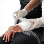 employee hand being wrapped in gauze and bandage