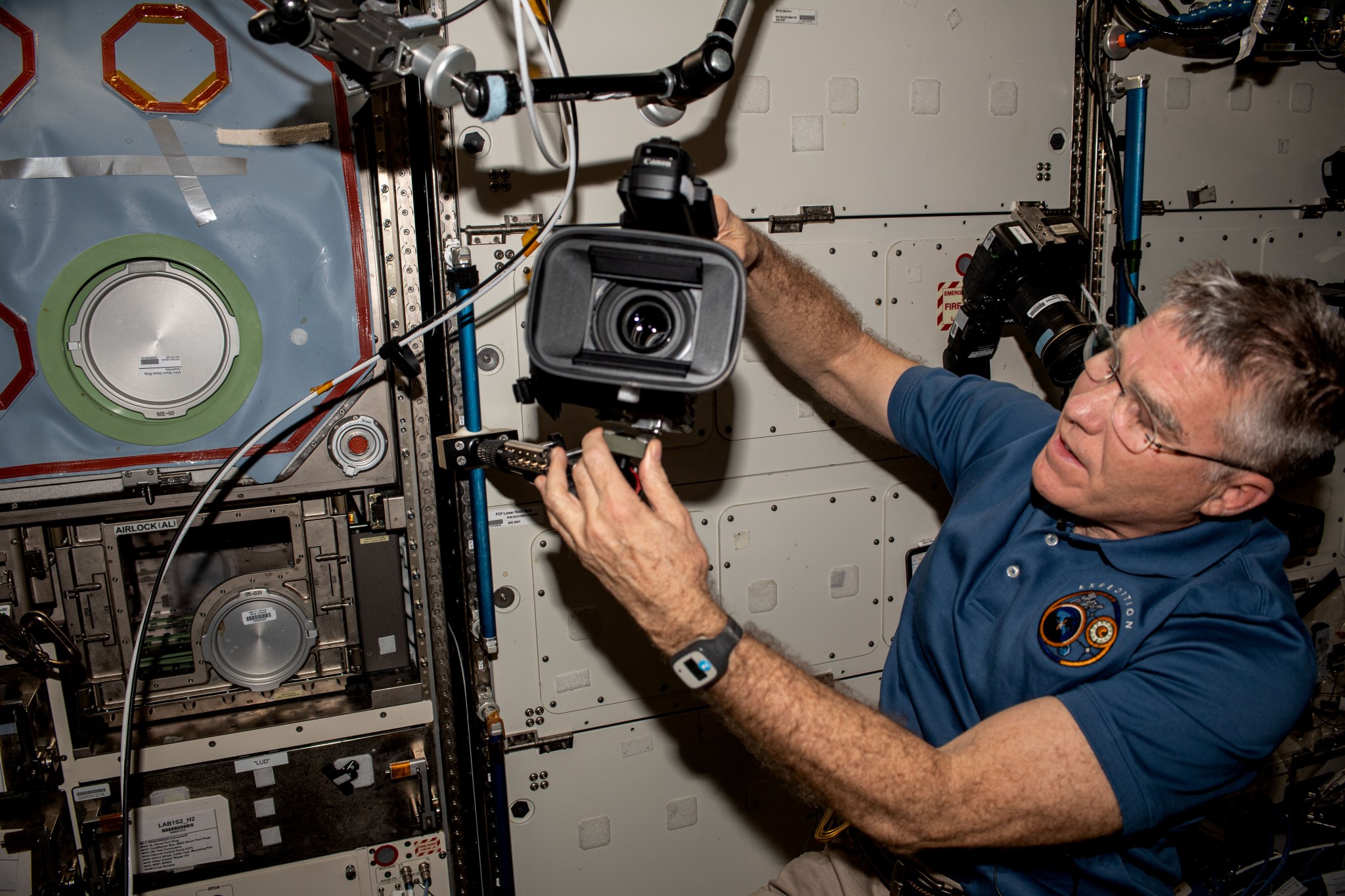 NASA astronaut Stephen Bowen sets up for a test of the Hunch Ball Clamp Monopod, a mounting system for cameras used to track targets on the ground or to take images and video inside the space station.