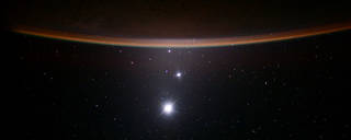 The image reveals Earth’s Moon, Venus, Jupiter, and Earth’s crescent, arranged from bottom to top.