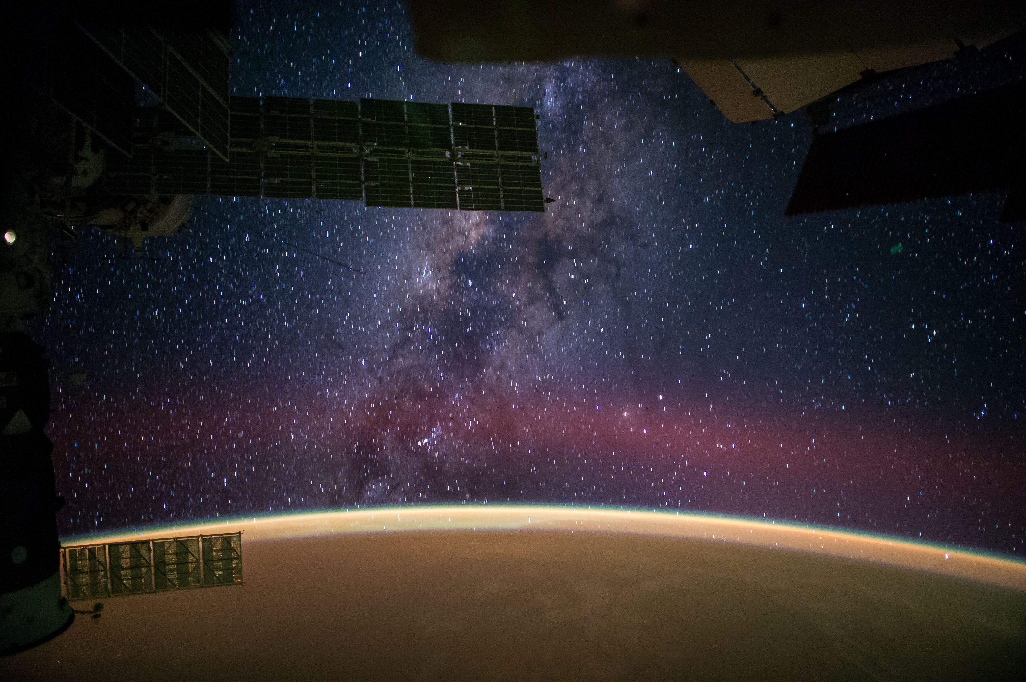 One of the Expedition 41 crew members aboard the International Space Station, flying at an altitude of 222 nautical miles above a point in the Atlantic Ocean several hundred miles off the coast of Africa near the Tropic of Cancer, photographed this eye-catching panorama of the night sky and the Milky Way on Sept. 27. NASA astronaut Reid Wiseman, flight engineer, tweeted the image, which was taken with an electronic still camera, set with a 24mm focal length. In his accompanying comments, Wiseman stated, "Sahara sands make the Earth glow orange."