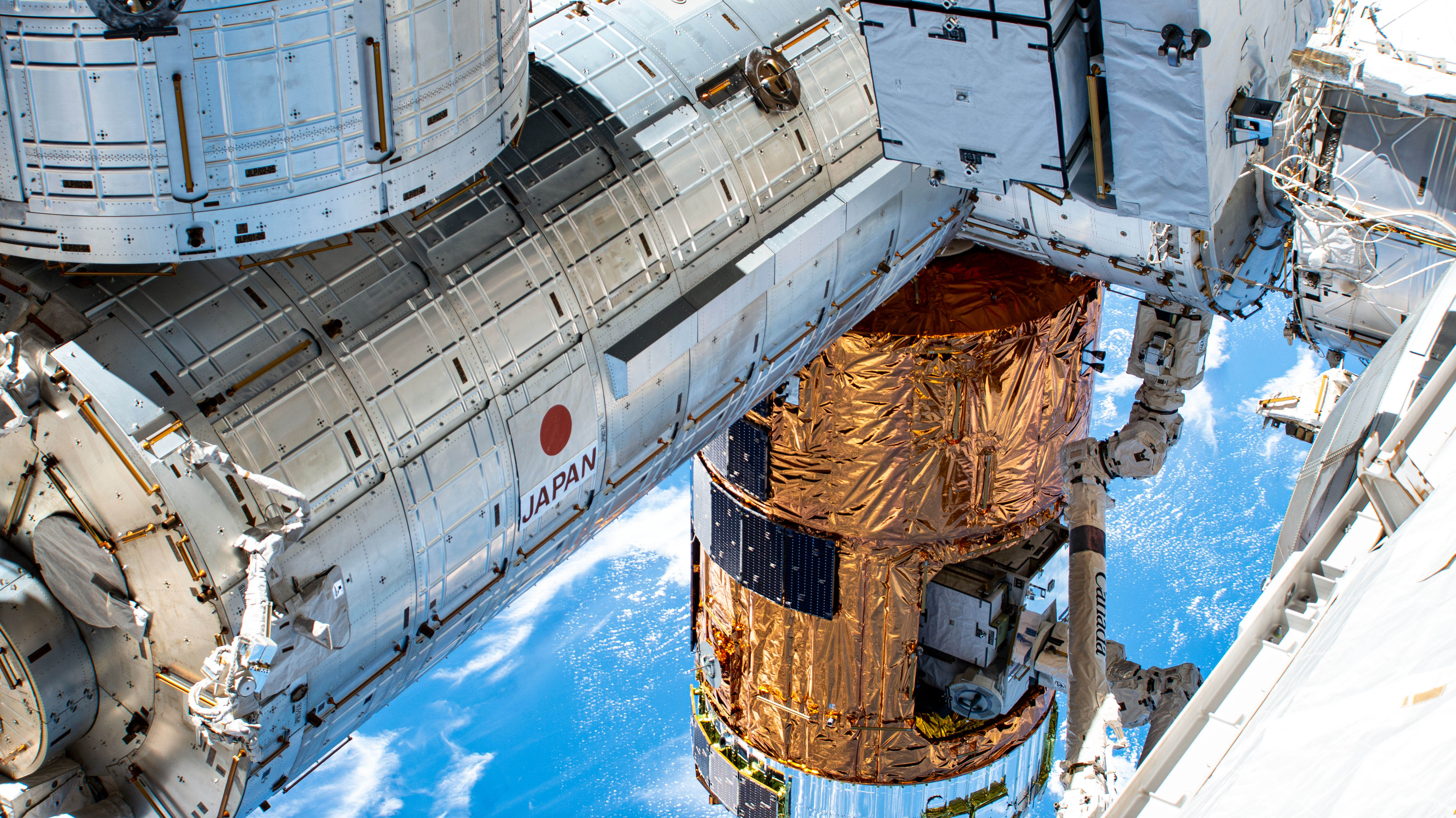 This oblique view from the port side of the International Space Station's truss structure shows JAXA's (Japan Aerospace Exploration Agency) and the Canadian Space Agency's (CSA) contribution to the orbiting lab. Included in this photograph is a major portion of the Kibo laboratory module, the H-II Transfer Vehicle-9 (HTV-9) resupply ship and the Canadarm2 robotic arm.