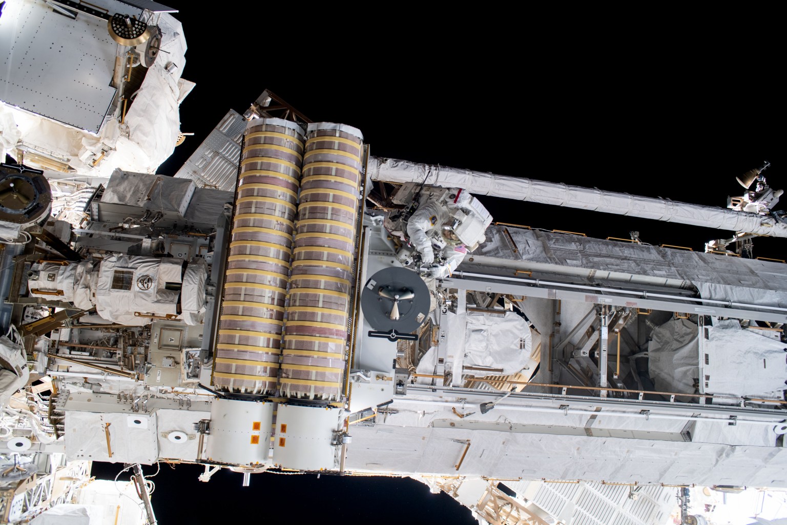 NASA spacewalker Stephen Bowen works to release a stowed roll-out solar array before installing it on the 1A power channel of the International Space Station's starboard truss structure.