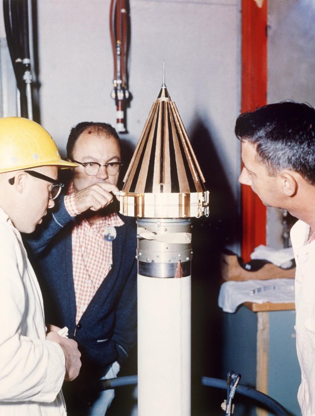 This image from March 2, 1959 shows engineers from NASA's Jet Propulsion Laboratory checking NASA's Pioneer 4 spacecraft, the gold-and-black-colored cone sitting atop the white fourth-stage motor of the Juno II launch vehicle in Florida.