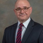 Portrait of a man in a suit and tie his name is Kent Chojnacki