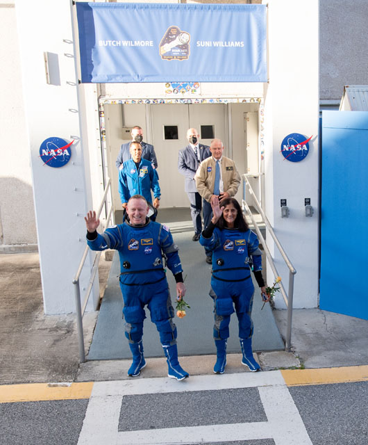 Astronauts Butch Wilmore and Suni Williams wave to the crowd prior to launch of the Boeing Starliner while in their blue spacesuits.