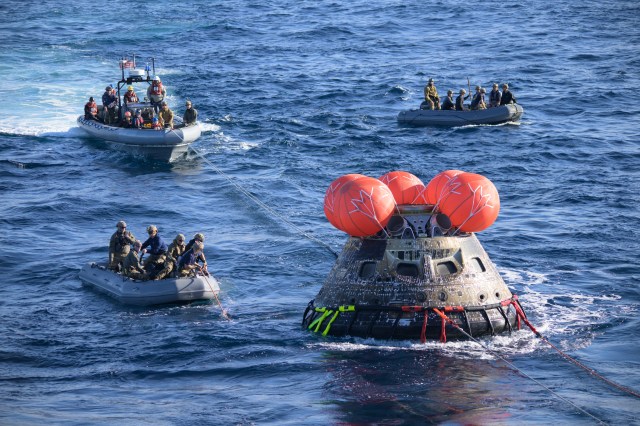 U.S. Navy divers help recover the Orion spacecraft after it splashed down in the Pacific Ocean on Dec. 11, 2022.