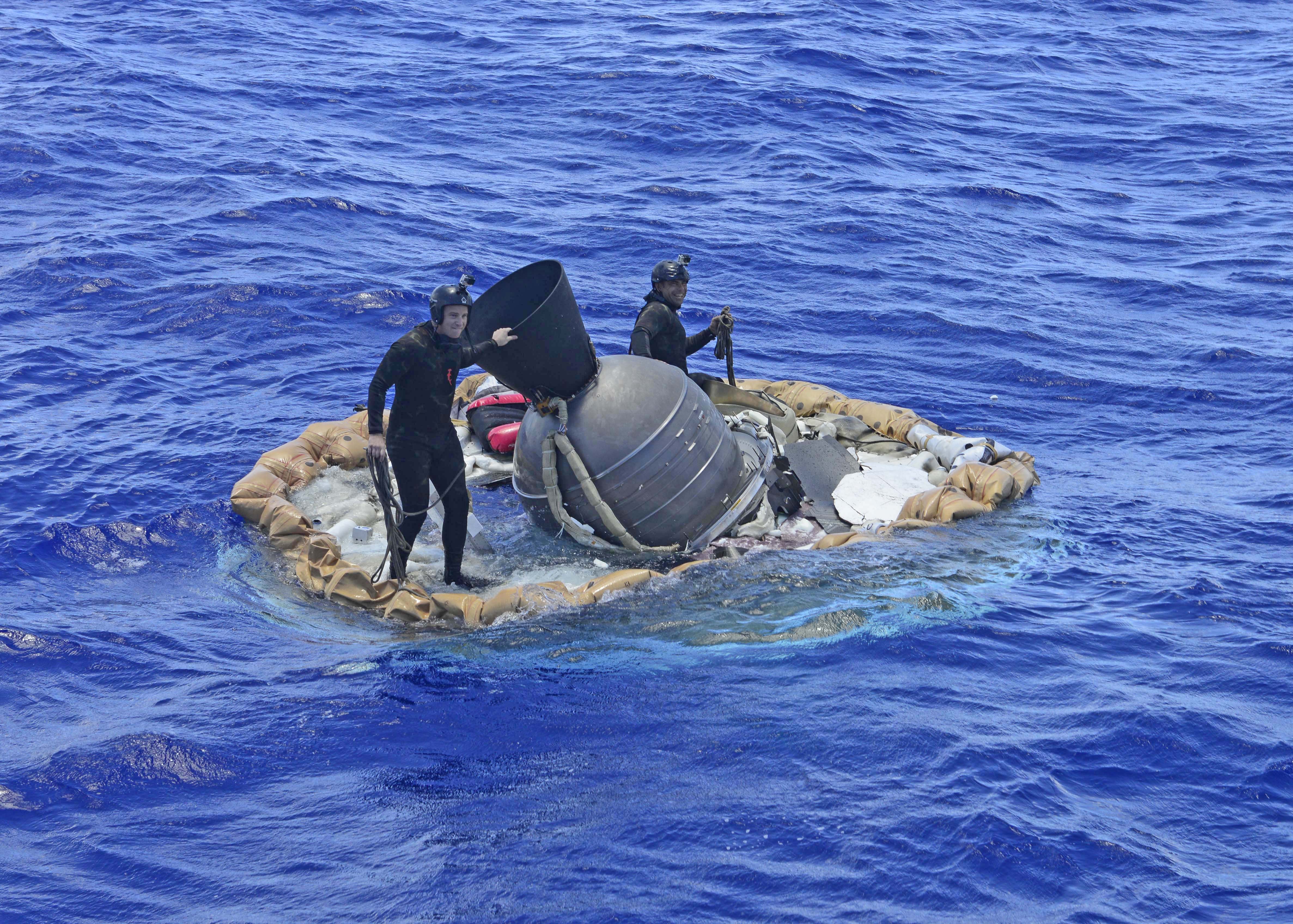 Two members of the U.S. Navy's Mobile Diving Salvage Unit (MDSU) 1 Explosive Ordnance Detachment work on recovering the test vehicle for NASA's Low-Density Supersonic Decelerator (LDSD) project.