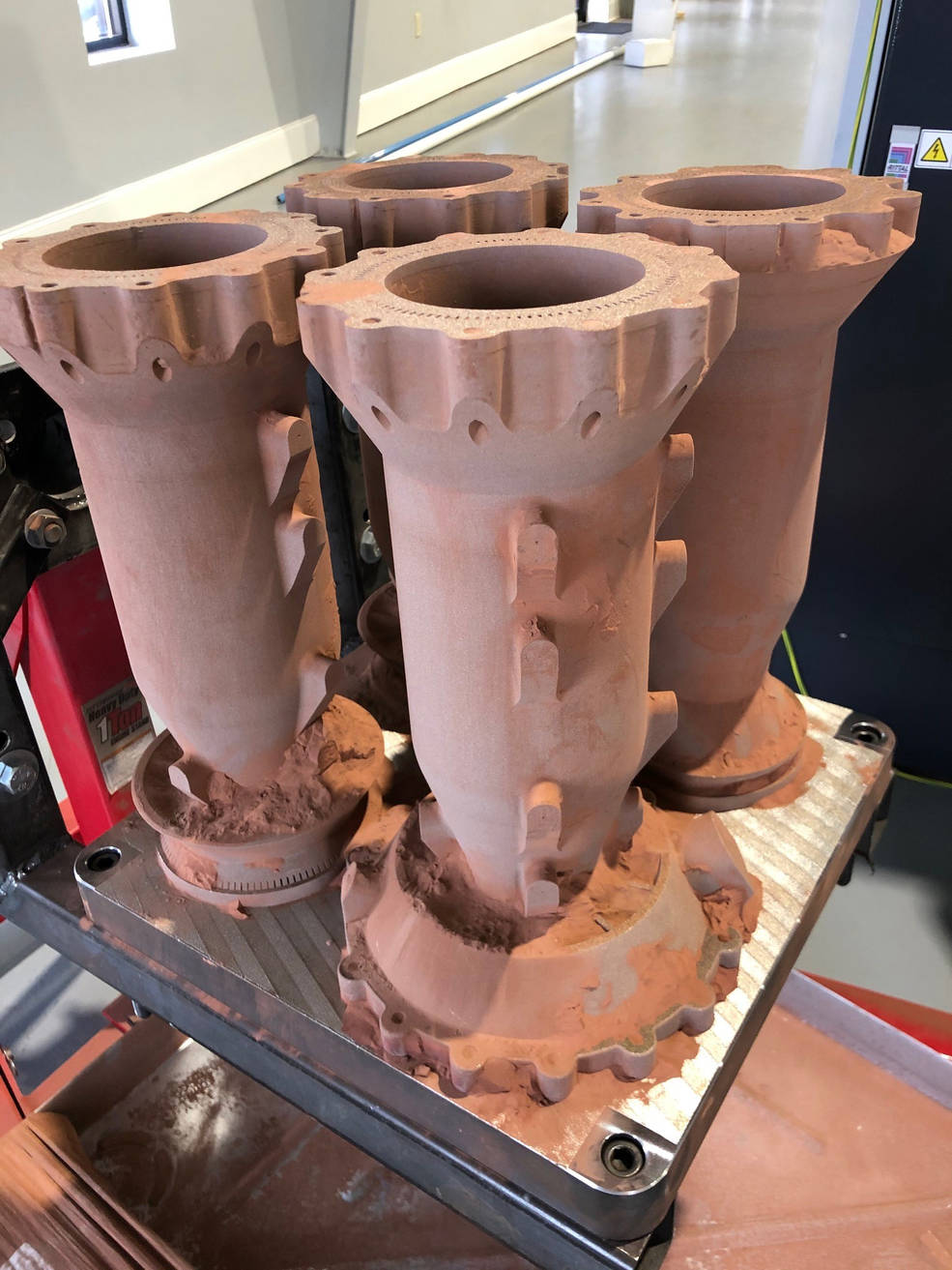 An additive manufactured combustion chamber is shown mid-process. Credit: NASA. 