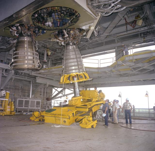 Employees at NASA’s Stennis Space Center, then known as National Space Technology Laboratories, install a space shuttle main engine on the B-2 Test Stand in preparation for testing the space shuttle main propulsion test article (MPTA).