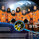 Partial screen capture of the Discovery STS-131 crew poster showing seven astronauts in orange flight suits with Earth in the background and the ISS in the bottom right corner. The mission patch and informational text is also visible.
