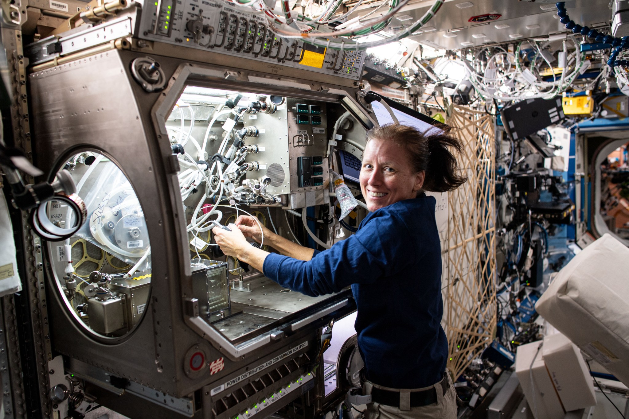 Expedition 64 Flight Engineer Shannon Walker sets up hardware inside the Microgravity Science Glovebox.