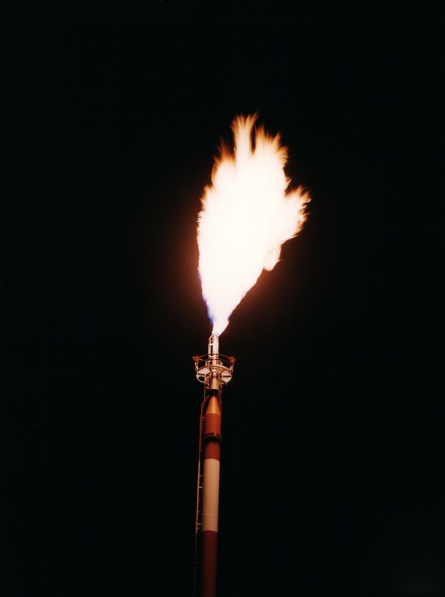 View of fire coming out of the flare stack at night.