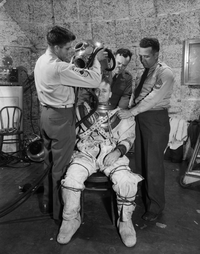 NASA workers placing Ray H. Wright into a diving suit.