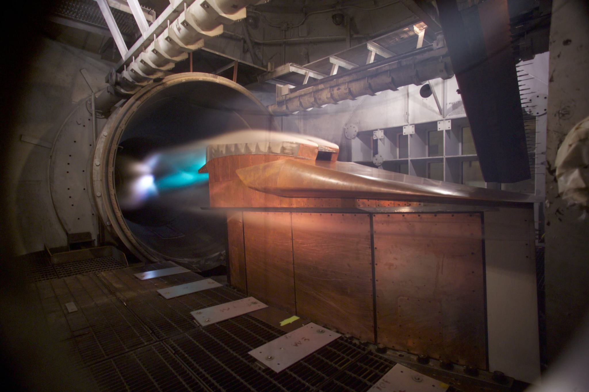 An angled, rectangular block of metal fires into a round exhaust duct. Mist flows over the corners and around the whole model.