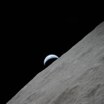 View of the crescent Earth rising above the lunar horizon over the Ritz Crater.