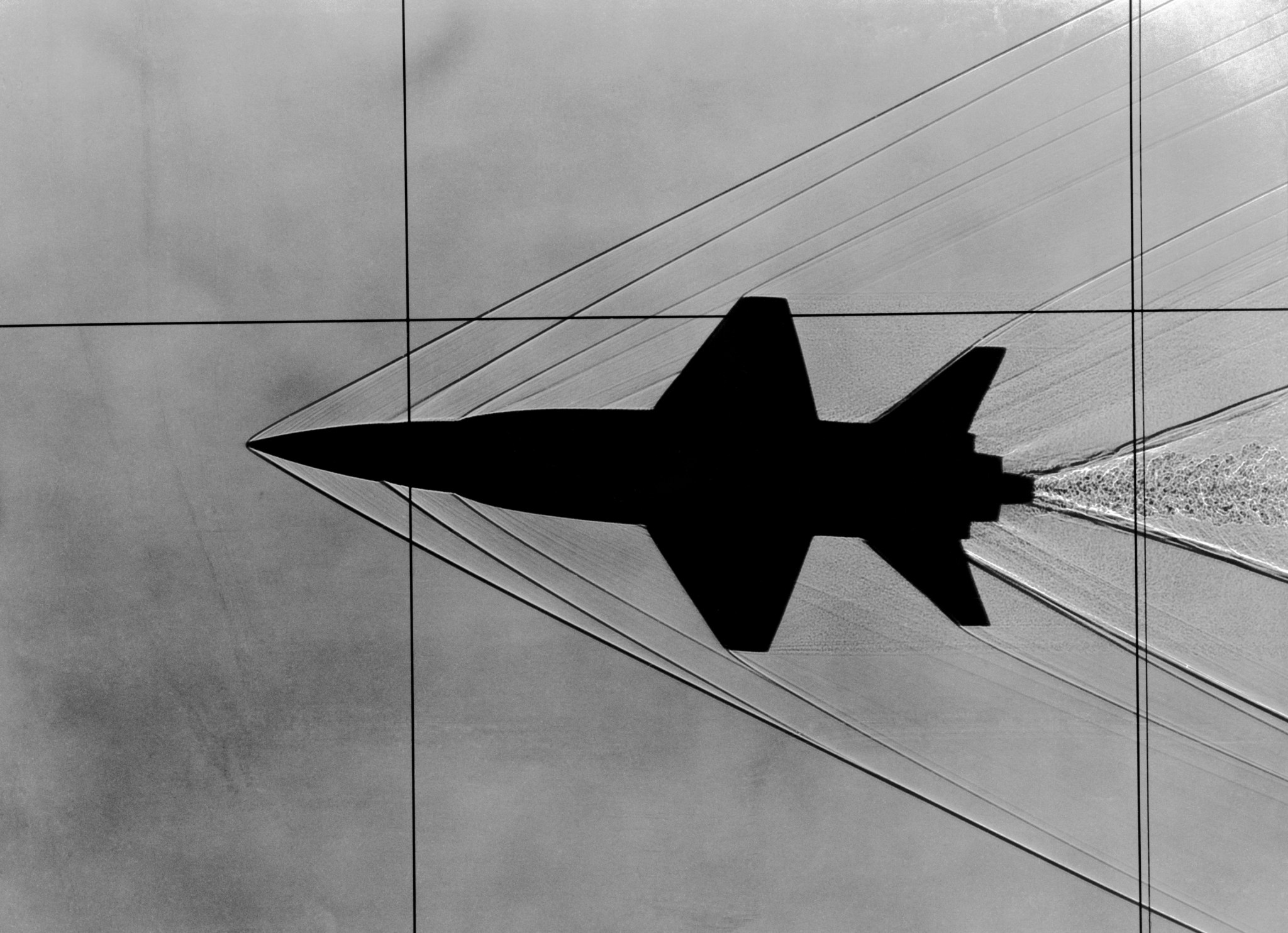 Shadowgraph of a model plane, showing the silhouette of the plane and lines extending from it at various points.