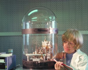 Bonnie Dalton looks through a glass enclosure with a test module inside for the Viking biological experiments.