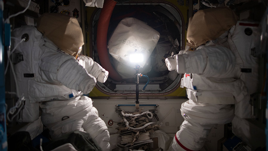 A pair of Extravehicular Mobility Units (EMUs), also known spacesuits, are pictured inside the space station's Quest airlock where spacewalks are staged by astronauts wearing the EMUs.