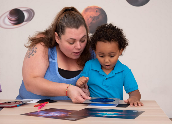 Adult and child play with science toys together