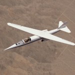 Overhead view of a plane in flight, with the wing slanted diagonally.