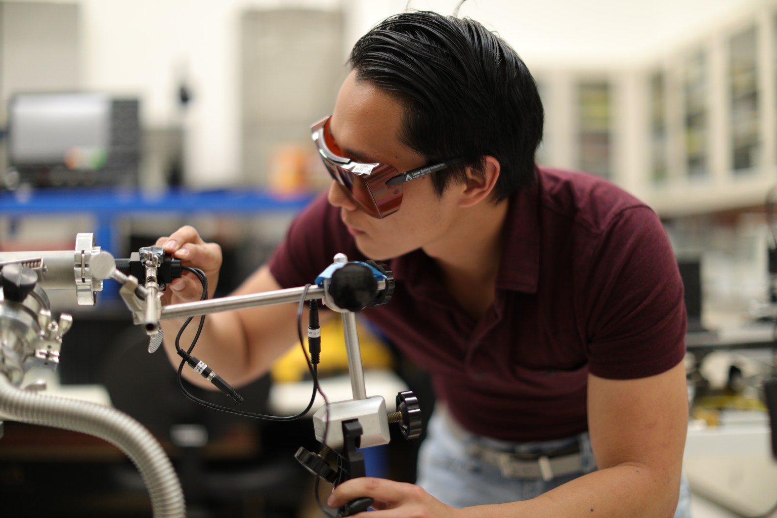 Aerospace engineer Jerry Wang uses a laser beam to determine the dust density inside the electrostatic precipitator, a technology under development to filter dust from the Martian atmosphere.